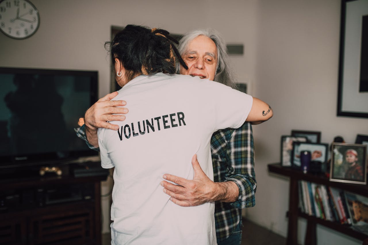 A volunteer embraces a senior woman in a heartfelt moment of support and love.